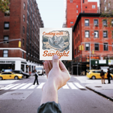 Cooking_With_Sunlight_WhiteSquareSticker_Hand_Mockup.png_16183568